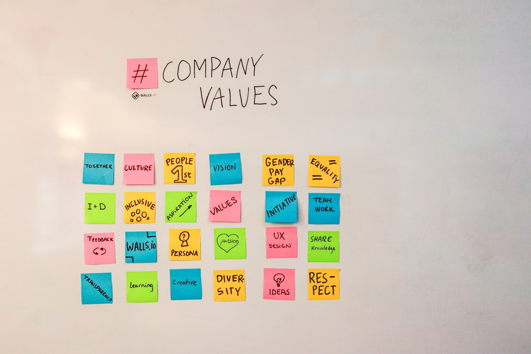 Whiteboard covered in sticky notes with company values written on them
